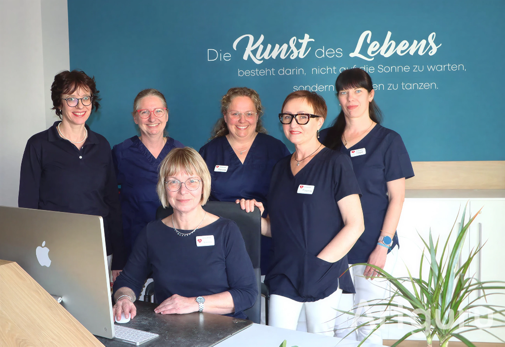 Ein Gruppenfoto des gesamten Teams im Empfangsbereich der Praxis am Meyenburgpark.